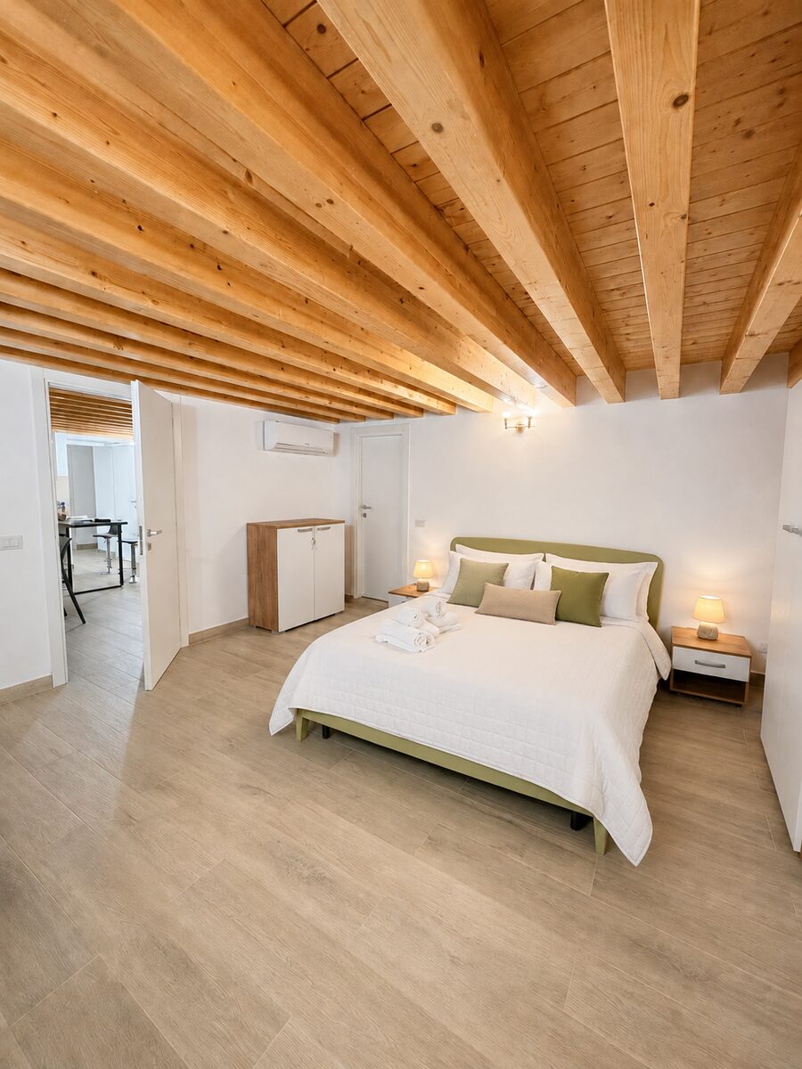 Camera da letto luminosa con soffitto a travi in legno dell'Urban Retreat